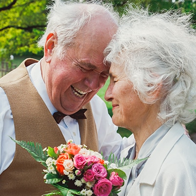 An elderly couple dressed up and smiling
